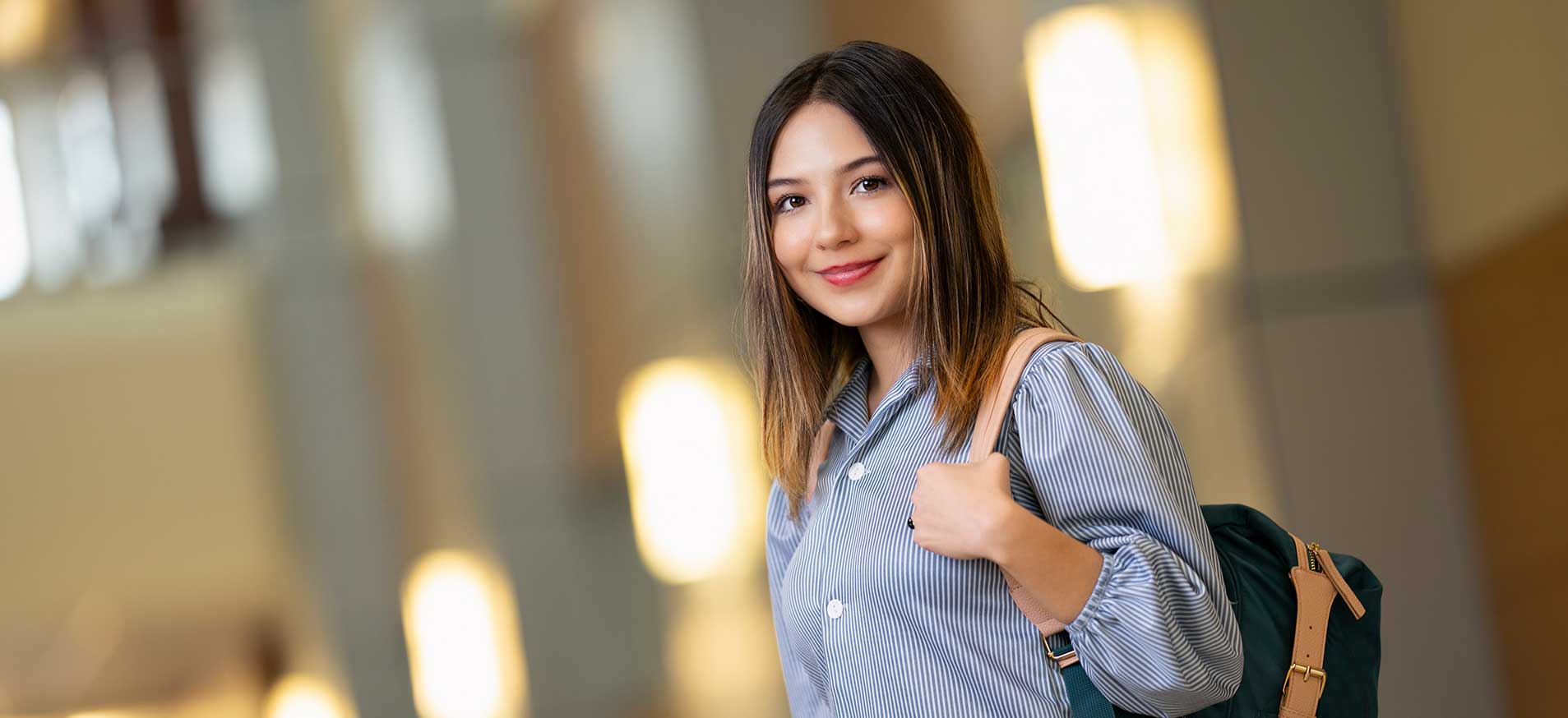 Female with backpack smiling at camera