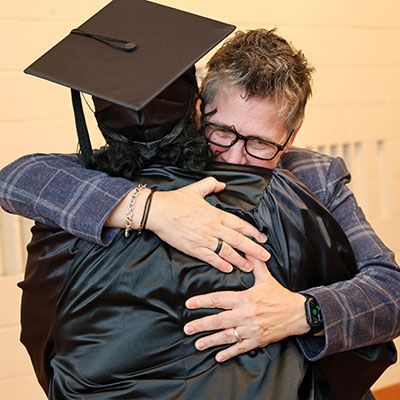 Opportunity High School Diploma instructor LaMona Lemarr hugging a graduate